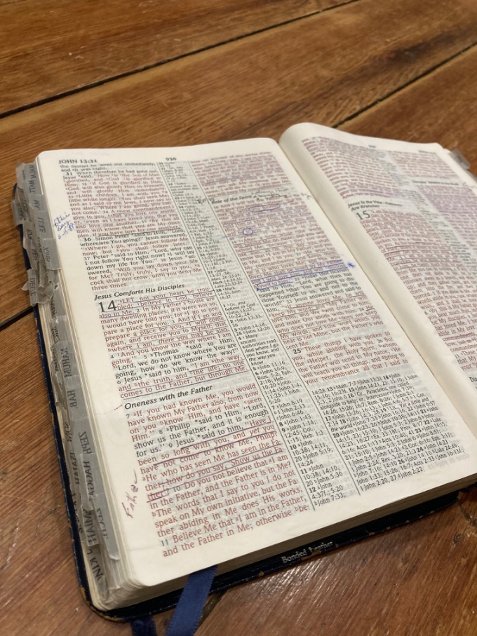 An open Bible with notes in the margins